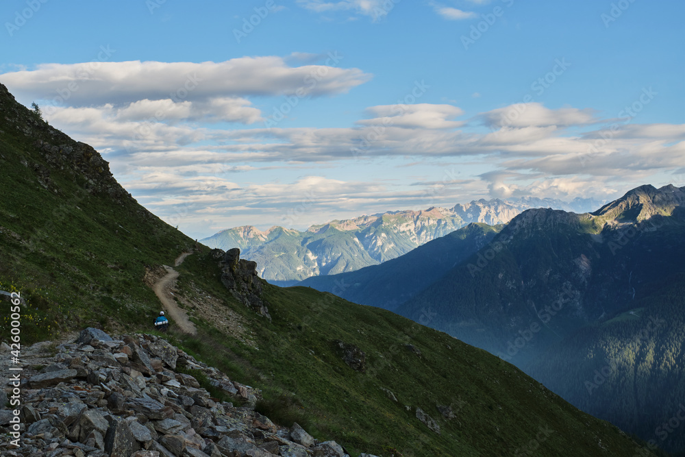 A girl is walking along a path into the mountain A girl is walking along a path into the mountain