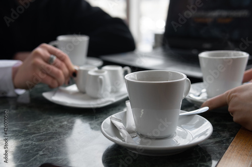 meeting in a cafe for a cup of coffee. laptop on the table. Conversation and discussion. Business and work concept. Without the visibility of faces