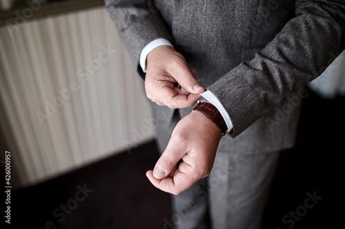 Businessman wears a jacket,male hands closeup,groom getting ready in the morning before wedding ceremony © bondvit