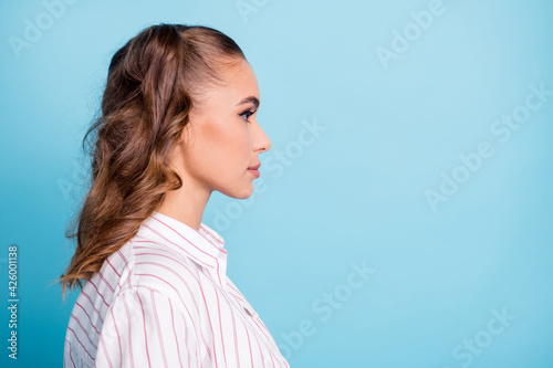 Profile side view portrait of attractive confident brown-haired girl copy empty place space isolated over bright blue color background