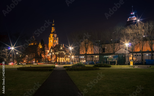 a night shot of the path leading to illuminated old buildings in Szczecin