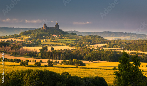 view of the fields and forests at the foot of the hill with the ruins of the castle