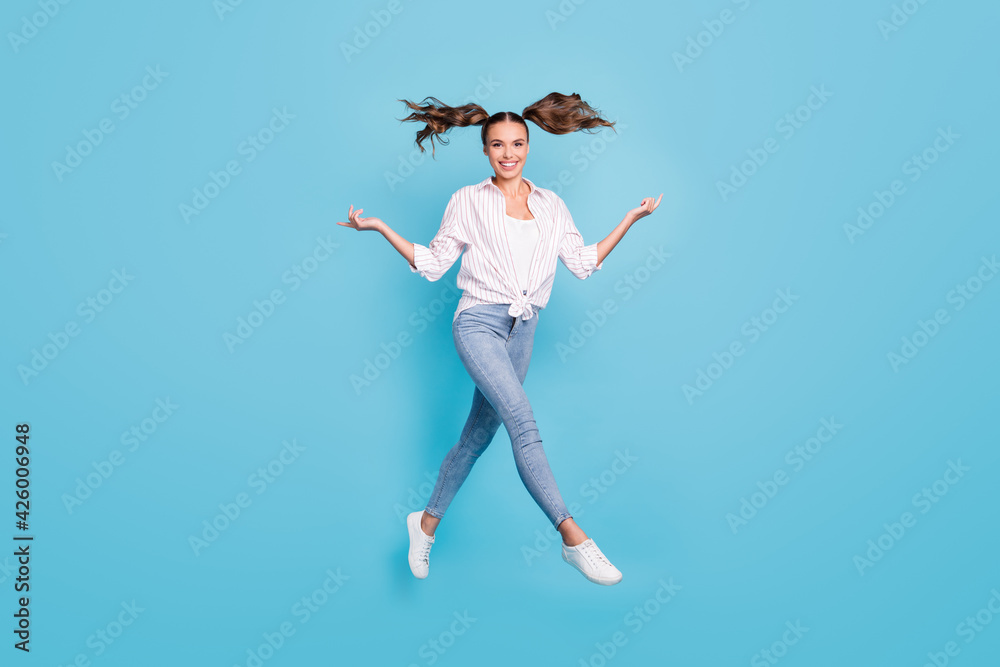 Full length body size view of attractive funky cheerful girl jumping having fun going enjoying isolated on bright blue color background Full length body size view of attractive funky cheerful girl jumping having fun going enjoying isolated on bright blue color background