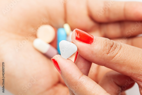 Macro Close up of medicinal or herbal multi-color tablet  capsule  and pill on a female hand palm. Top view 