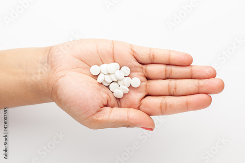 Macro Close up of medicinal or herbal white color pill on a female hand palm. Top view,