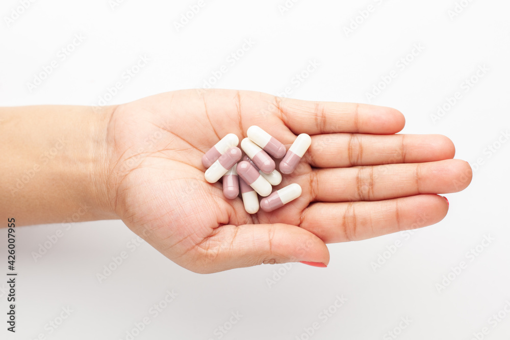 Macro Close up of medicinal or herbal multi-color tablet, capsule, and pill on a female hand palm. Top view, Macro Close up of medicinal or herbal multi-color tablet, capsule, and pill on a female hand palm. Top view,