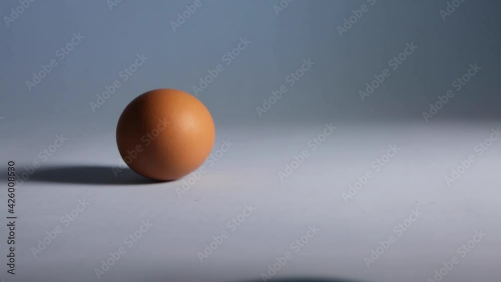 Easter Egg Roll. Close up video eggs rolling on blue table from hands. Holiday decoration. A woman rolls with eggs. Chicken eggs in the hands of a woman. Easter Egg Roll. Close up video eggs rolling on blue table from hands. Holiday decoration. A woman rolls with eggs. Chicken eggs in the hands of a woman.