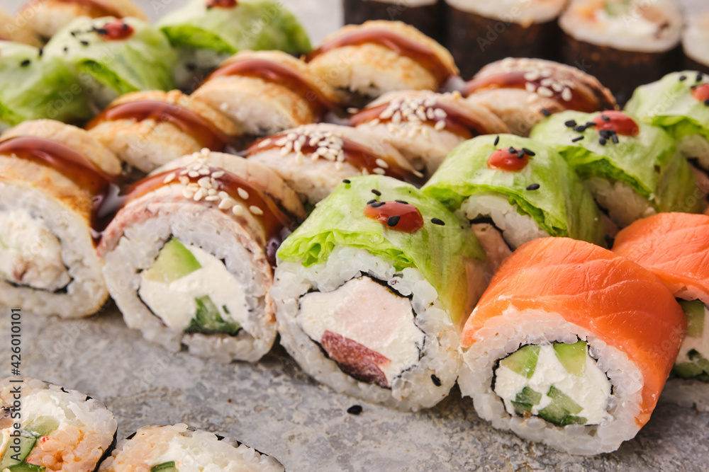 Japanese traditional cuisine: sushi. Assortment of sushi rolls on a gray background Japanese traditional cuisine: sushi. Assortment of sushi rolls on a gray background