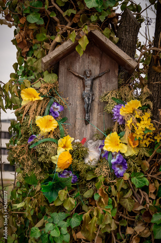 przydrożna kapliczka z krucyfiksem przystrojona kwiatami  © Henryk Niestrój