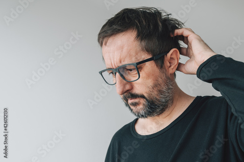 Forgetfulness - forgetful mid-adult man with eyeglasses photo