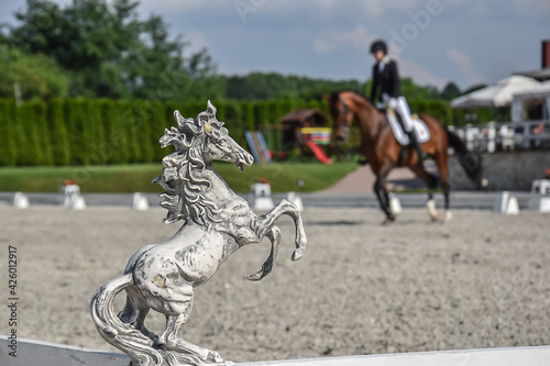 Kamienna rzeźba figurka konia, na tle jeździec.