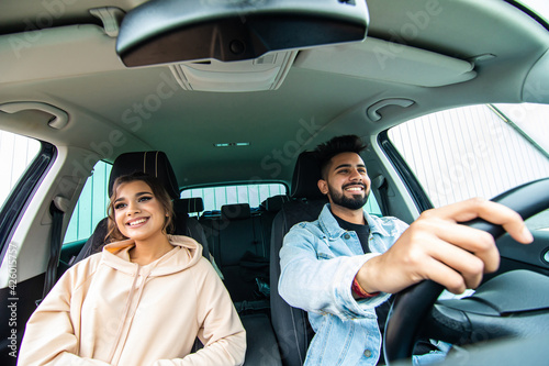 Front view of indian couple man and woman sitting in car. Enjoying travel concept.