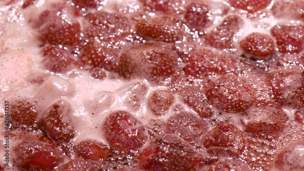 Strawberry jam is boiling, detailed shooting. Close-up of strawberry jelly boiling in a saucepan. Preparation of strawberry jelly, marmalade or strawberry sauce. Strawberry jam is boiling, detailed shooting. Close-up of strawberry jelly boiling in a saucepan. Preparation of strawberry jelly, marmalade or strawberry sauce.