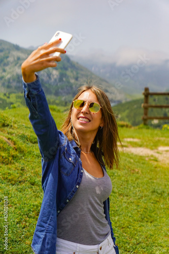 a girl in the mountain making a selfie with her phone