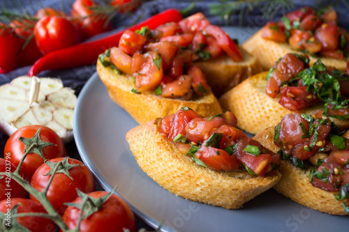 Italian bruschetta with roasted tomatoes, basil and garlic. Top view photo of savory toast. Healthy eating concept. 