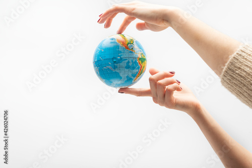 Globe at the tip of fingers. Female hand holds globe. World in human hands