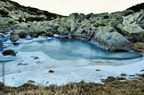frozen lake and rocks in the mountains