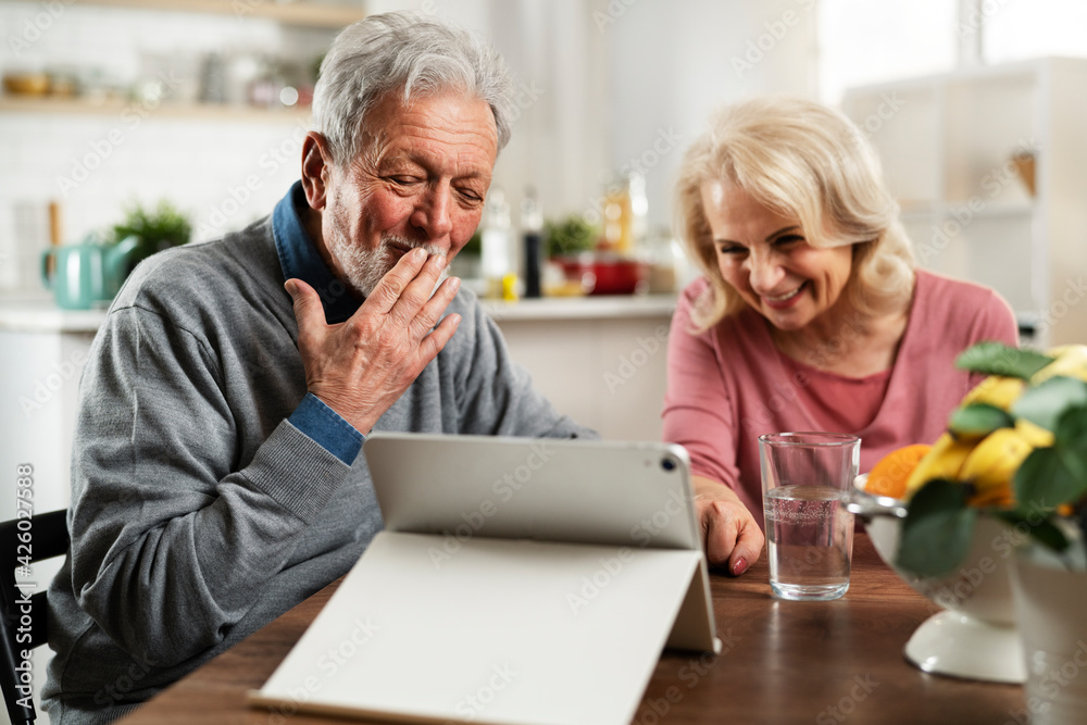 Senior couple having video call. Happy husband and wife talking with their grandkids. Senior couple having video call. Happy husband and wife talking with their grandkids.