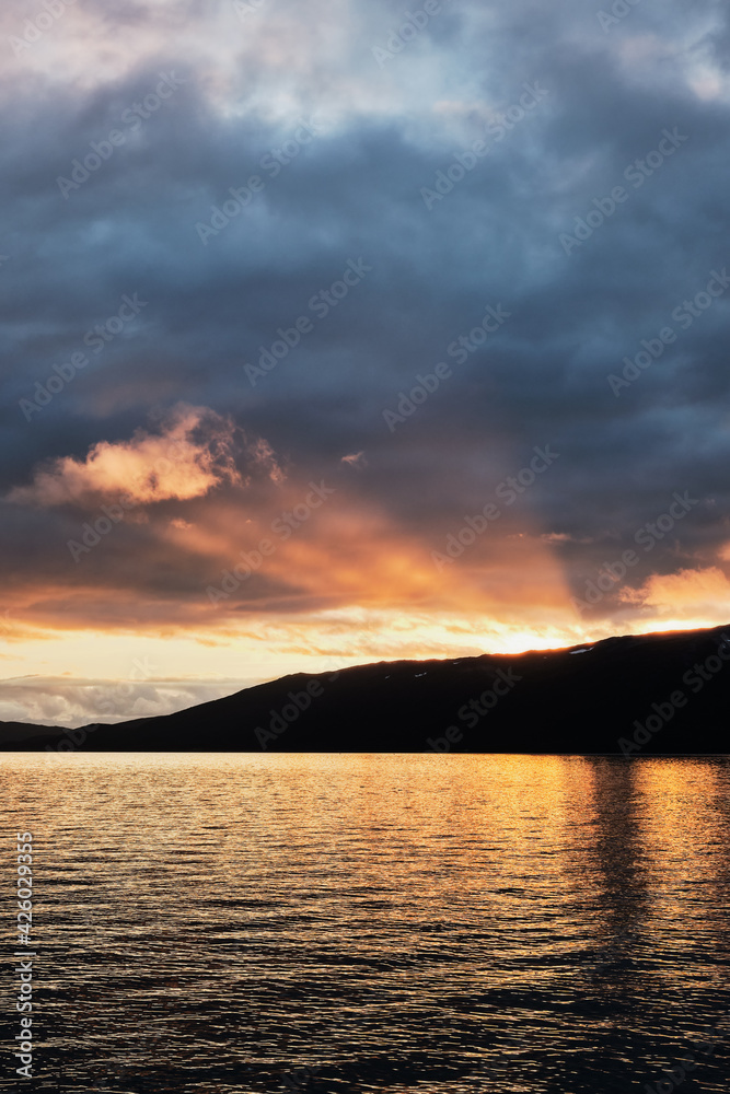 Scenic view of sun rays passing through the clouds in Norway during a beautiful cloudy sunset