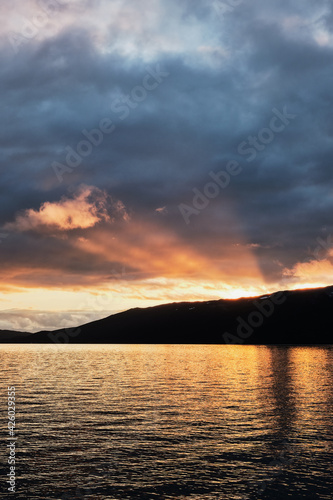 Scenic view of sun rays passing through the clouds in Norway during a beautiful cloudy sunset