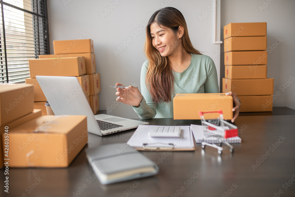 Portrait of Starting small businesses SME owners female entrepreneurs Write the address on receipt box and check online orders, prepare to pack the boxes, sell,customers, sme business ideas online. Portrait of Starting small businesses SME owners female entrepreneurs Write the address on receipt box and check online orders, prepare to pack the boxes, sell,customers, sme business ideas online.