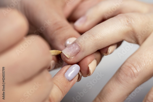 Manicure hand nail care with a special device in a beauty salon by a manicure specialist. Close-up. Space for the text.