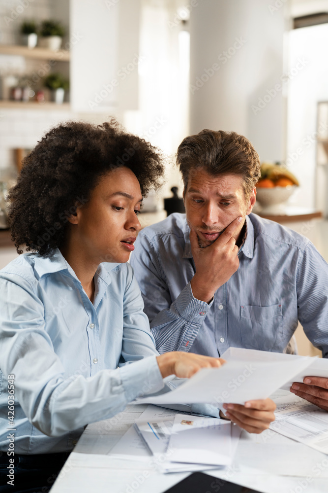 Young couple preparing bills to pay. Stressed woman and man having financial problems.