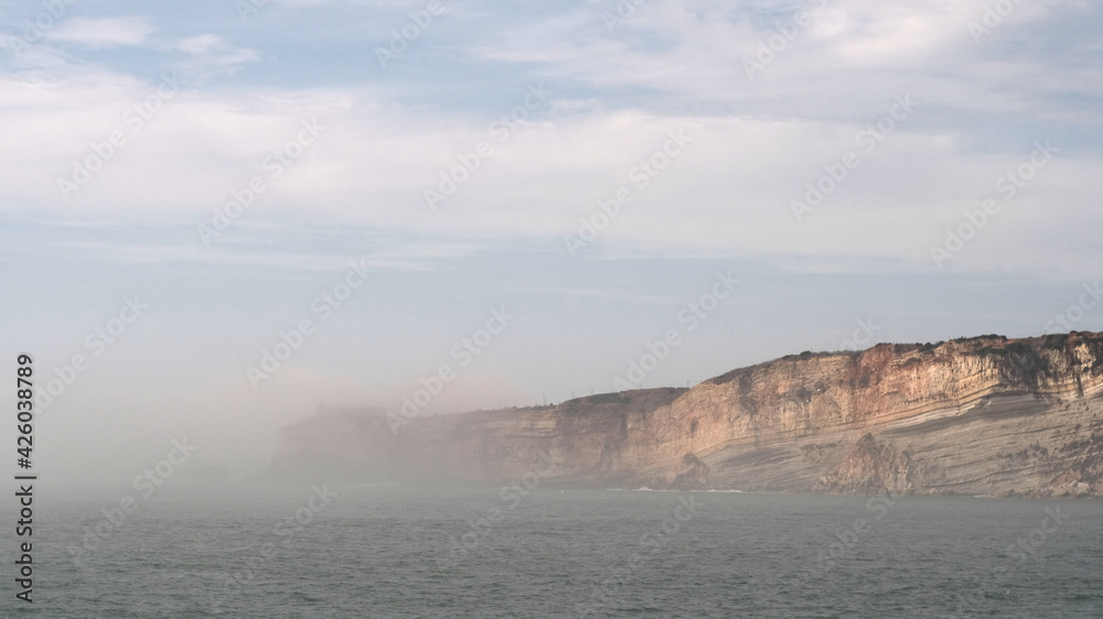 Beach in Nazare, Portugal with low mist and clouds