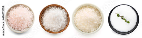 Bowls of different salt on white background