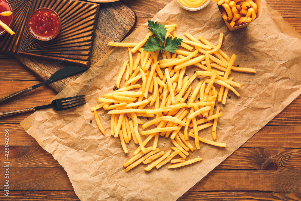 Tasty french fries on wooden background Tasty french fries on wooden background