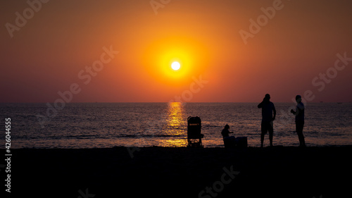 Friends watching the sunset in Kata Beach Phuket Thailand