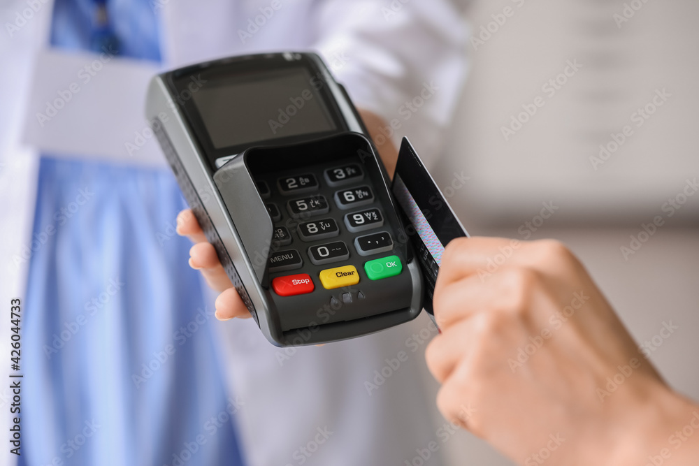 Patient paying for consultation in clinic via terminal, closeup Patient paying for consultation in clinic via terminal, closeup