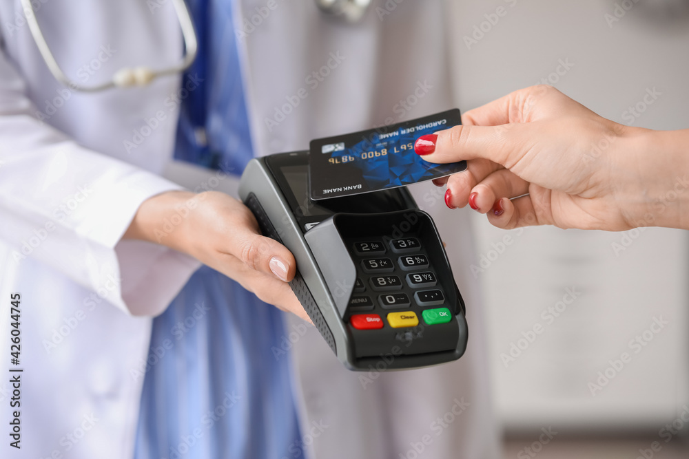 Patient paying for consultation in clinic via terminal, closeup Patient paying for consultation in clinic via terminal, closeup