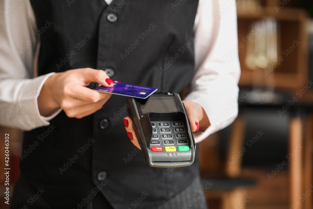 Waiter with payment terminal and credit card in cafe, closeup Waiter with payment terminal and credit card in cafe, closeup