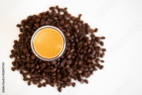 Fototapeta Naklejka Na Ścianę i Meble -  Espresso coffee in a cup surrounding with medium dark roasted coffee beans and coffee capsule