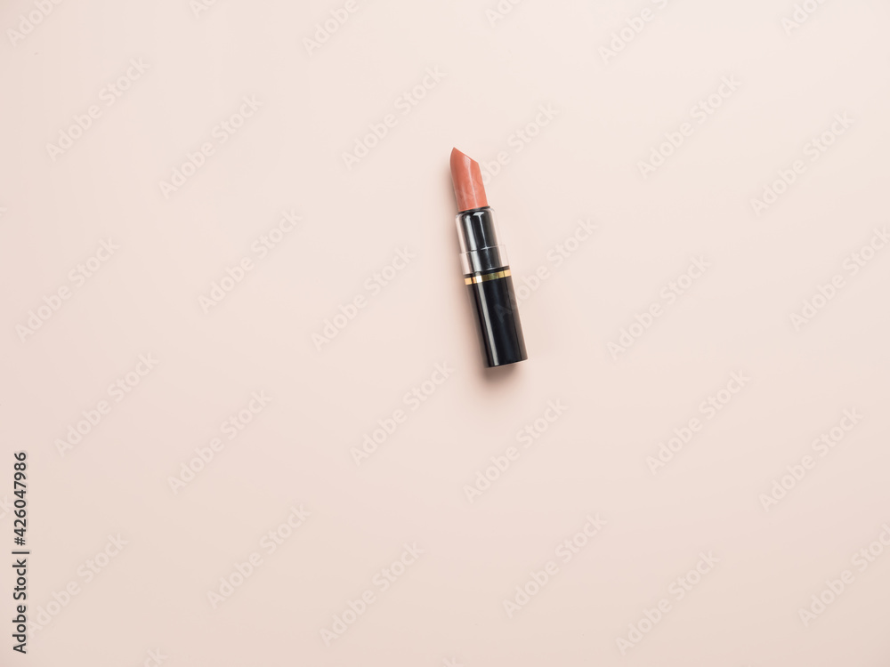 Open lipstick in brown shades on a powdery background. View from above Open lipstick in brown shades on a powdery background. View from above