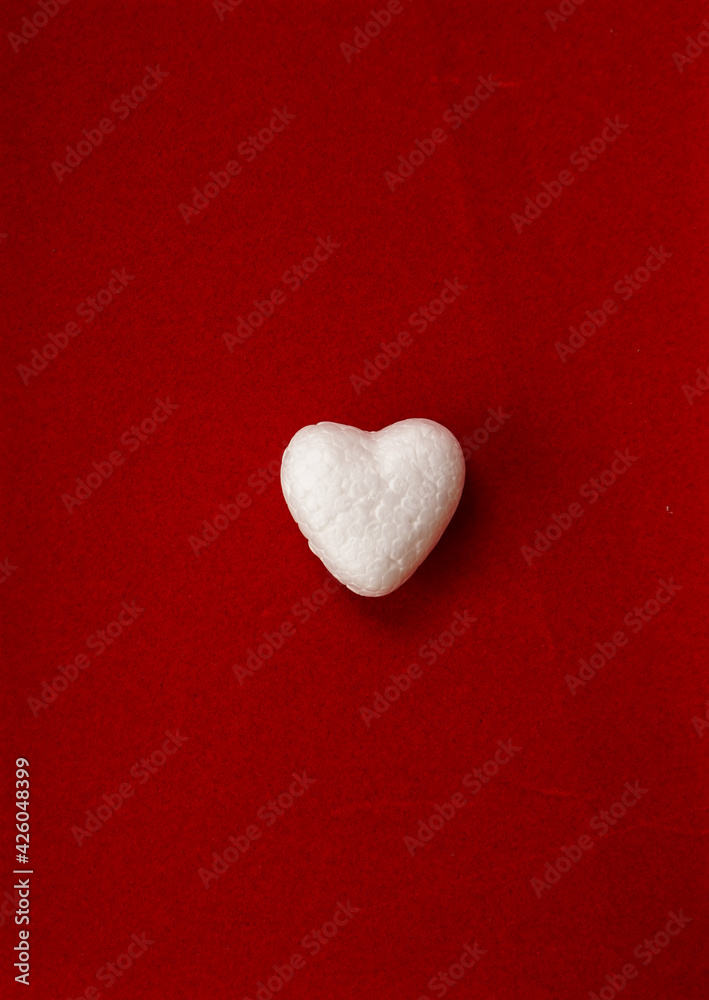 Fototapeta premium white heart on red background. Copy space. advertisement idea.Minimal concept flat lay