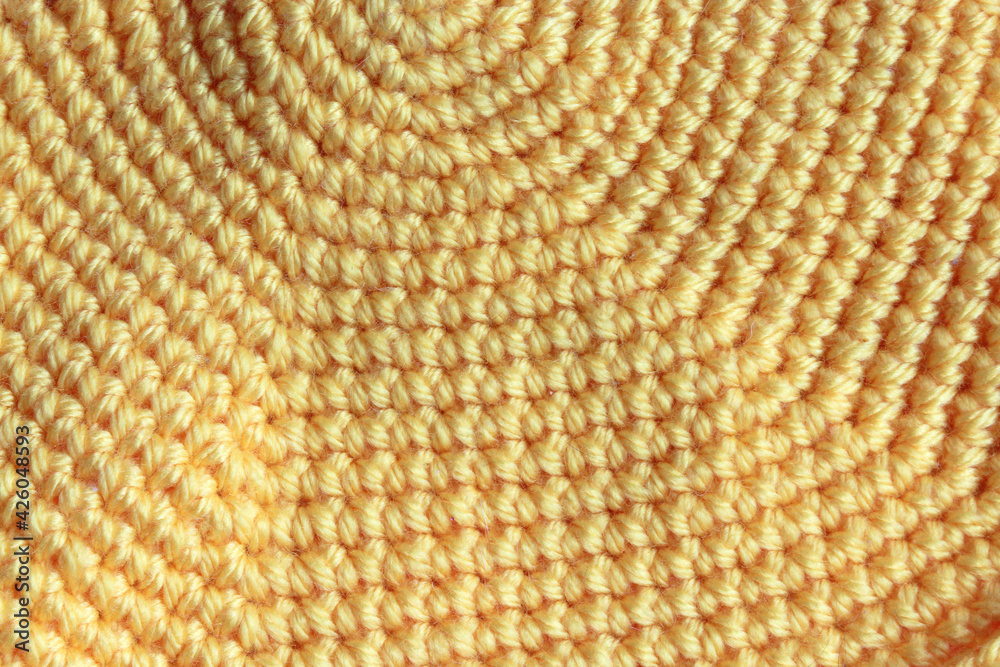 Cute yellow knitted background, yarn. Crocheted product close-up Cute yellow knitted background, yarn. Crocheted product close-up