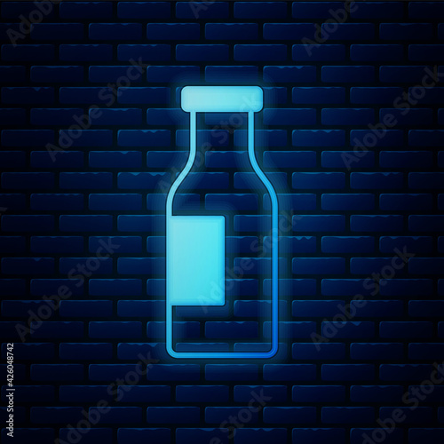 Glowing neon Closed glass bottle with milk icon isolated on brick wall background. Vector