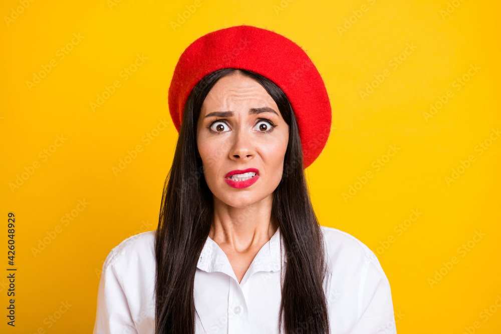 Photo of scared worried young woman wear red beret white shirt problem isolated on bright yellow color background Photo of scared worried young woman wear red beret white shirt problem isolated on bright yellow color background