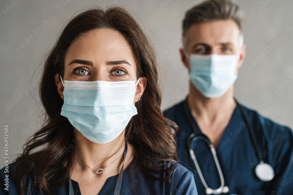 Two confident doctors in medical masks standing Two confident doctors in medical masks standing