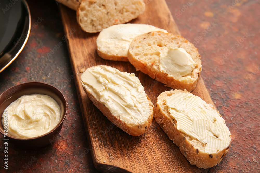 Slices of fresh bread with butter on grunge background, closeup