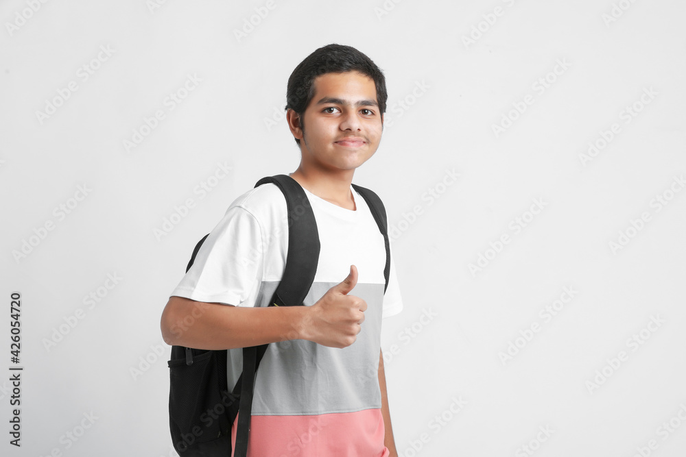 Young indian college student holding bag on white background. Young indian college student holding bag on white background.