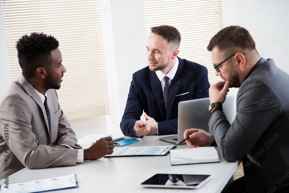 Businessmen sitting around the office desk and discussing the project