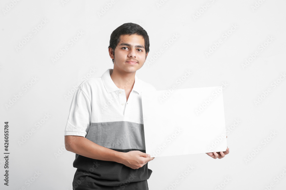 Young indian college student showing white board on white background Young indian college student showing white board on white background