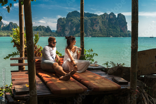 Beautiful couple relaxing on an island off the coast.  Young couple by the sea. A man and a woman travel to Thailand. Couple in love at the lagoon. Honeymoon trip. Relax on the island. Wedding travel © MISHA