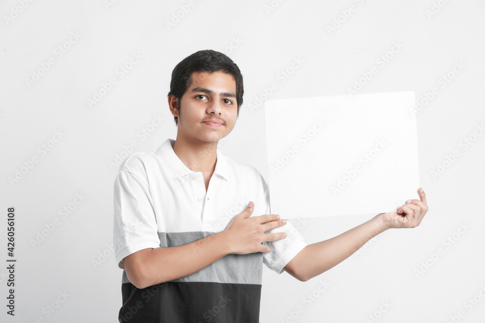Young indian college student showing white board on white background Young indian college student showing white board on white background