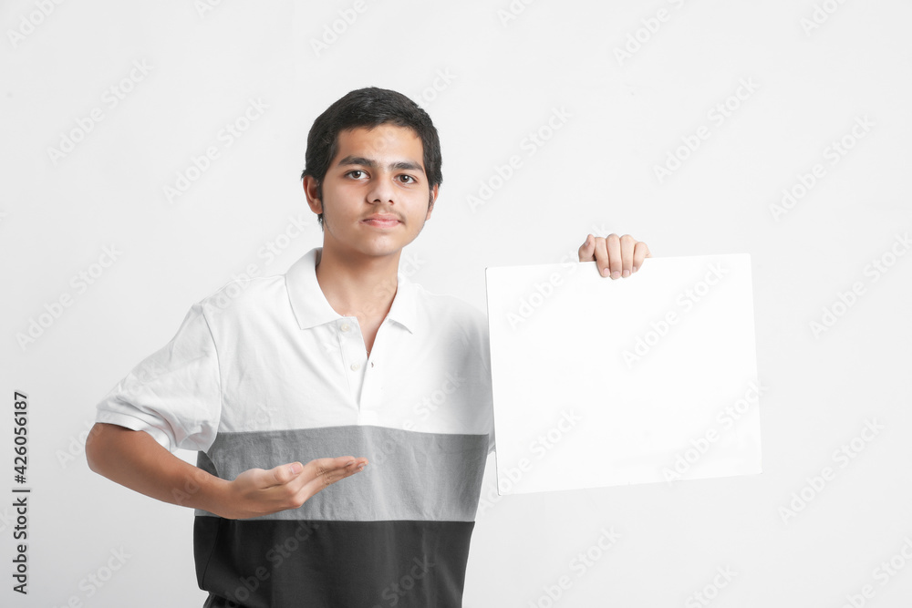 Young indian college student showing white board on white background Young indian college student showing white board on white background