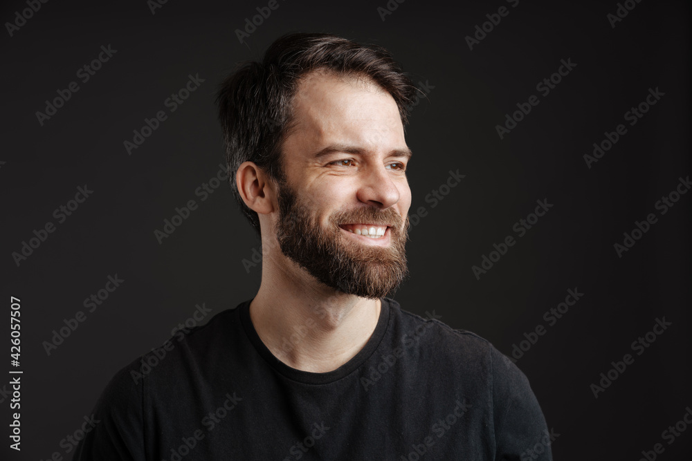 Bearded brunette white man smiling and looking aside