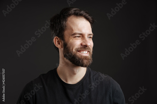 Bearded brunette white man smiling and looking aside © Drobot Dean